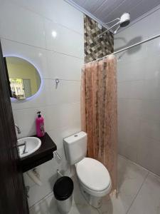 a small bathroom with a toilet and a sink at Kitnet privada confortável em Pontal do Sul in Pontal do Paraná