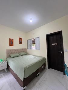 Schlafzimmer mit einem Bett und einem Fenster in der Unterkunft Kitnet privada confortável em Pontal do Sul in Pontal do Paraná