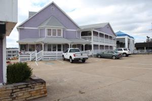 a purple house with a truck parked in a parking lot at 76 Family Inn in Branson