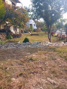 博卡拉的住宿－HIMALAYAN AAMA APARTMENT，房屋前设有长凳的公园