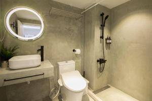 a bathroom with a white toilet and a mirror at 所在行旅-渡咕所在UrbanAbode DUGU in Taipei