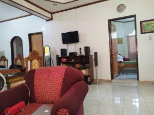 sala de estar con sofá rojo y TV en Banaga Residence, en Talibon