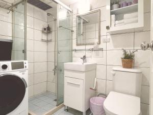 台北的住宿－所在行旅-渡咕所在UrbanAbode DUGU，浴室配有卫生间、盥洗盆和淋浴。
