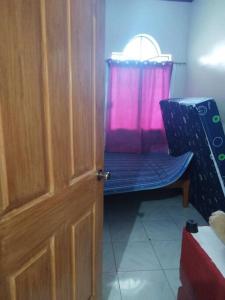 una puerta a una habitación con una silla y una ventana en Banaga Residence, en Talibon