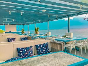 a restaurant on the beach with blue tables and chairs at SUNTORINI BOUTIQUE HOTEL in Vung Tau