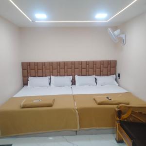 a bedroom with a large bed with a large headboard at Grand Celebration Resort in Neral