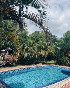 a swimming pool in a yard with palm trees at A'Famosa Villas in Ayer Keroh