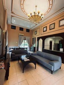 un grand salon avec des canapés et un lustre dans l'établissement A'Famosa Villas, à Ayer Keroh