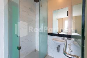 uma casa de banho com um lavatório e um espelho em Ichiza Room RedPartner em Jakarta