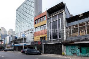 um edifício numa rua com carros estacionados em frente em Ichiza Room RedPartner em Jakarta