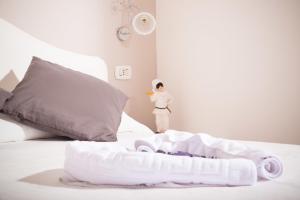 ナポリにあるB&B Lungomareの白いベビーベッド付きのベッドの横に立つ人形