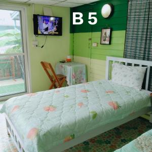 1 dormitorio con 1 cama en una habitación con TV en Ban Kru Ae Homestay en Bangkok