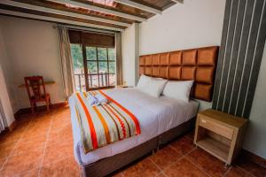 ein Schlafzimmer mit einem großen Bett und einem Fenster in der Unterkunft NaturaLodge Machu Picchu in Machu Picchu