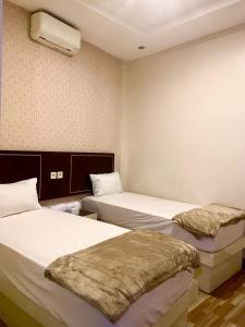 a hotel room with two beds and a fan at Luna Guest House in Tanjungkarang-Telukbetung