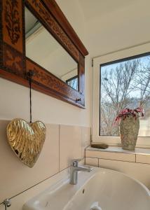 baño con espejo en forma de corazón y lavabo en Glasperlenspiel... ankommen und Zuhause fühlen... Apart-VL en Calw