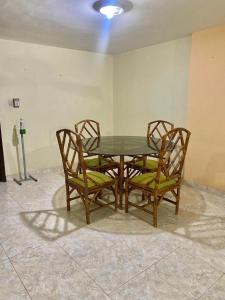 a dining room table with two chairs and a glass top at Edificio Maratea Apt 704 El Rodadero in Santa Marta
