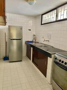 a kitchen with a stainless steel refrigerator and a sink at Edificio Maratea Apt 704 El Rodadero in Santa Marta
