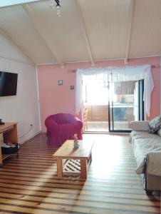 sala de estar con sofá y mesa de centro en Cabañas Catalina 5, en Tomé