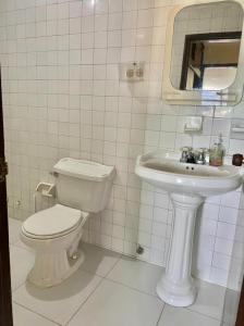 a white bathroom with a toilet and a sink at Edificio Maratea Apt 704 El Rodadero in Santa Marta