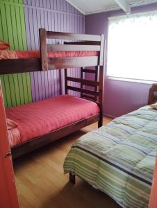 1 dormitorio con 2 literas y 1 cama en Cabañas Catalina 5, en Tomé