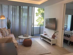 uma sala de estar com um sofá e uma televisão de ecrã plano em Apartment in South Melbourne em Melbourne