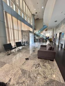 a lobby with a couch and chairs in a building at 705. Flat hotel Go Inn in Brasilia