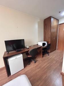 a room with a desk with a television and a computer at 705. Flat hotel Go Inn in Brasília