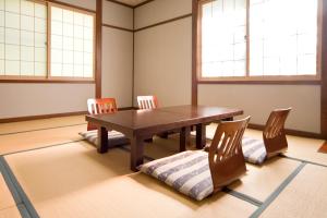 uma sala de jantar com uma mesa de madeira e cadeiras em Poetical em Matsumoto