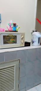kuchenka mikrofalowa na blacie w kuchni w obiekcie ห้องพักโอบอ้อมอารีย์ Orb Aom Aree w mieście Hua Hin