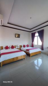 a bedroom with two beds and a window at Lak View hotel in Lien Son