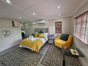 a bedroom with a bed and a yellow chair at Le-n-Biki Air B&B in Harrismith