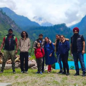 a group of people standing in front of a lake at Aman Resort, Tosh Village, Himachal Pradesh in Tosh