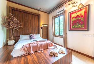 Un dormitorio con una cama y una mesa con zapatos. en Collection O 90858 Bentong Wellness Homestay Midland, en Kampong Sungai Chendarawi