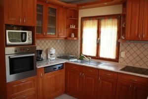 a kitchen with wooden cabinets and a microwave at Manner villa in Balatonalmádi