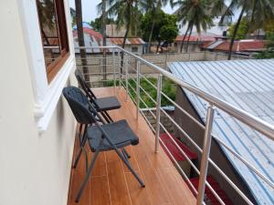 a black chair sitting on a balcony at Jodari Hotel Nungwi in Nungwi