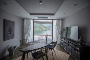 uma sala de jantar com uma mesa e uma grande janela em SS Resort em Gapyeong