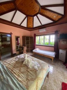 a bedroom with a large bed in a room with windows at Elje Villa in La Digue