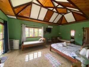 um quarto com paredes verdes e um tecto de madeira em Elje Villa em La Digue