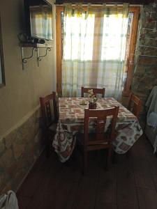uma mesa e cadeiras com uma mesa e uma janela em La Remulla em Paúls
