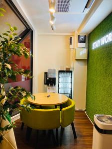 a table and chairs in a room with a green wall at ステイワーク錦糸町 in Tokyo