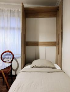 a bedroom with a bed and a chair and a window at Amrai in Ventspils