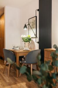 stół jadalny z krzesłami i wazon kwiatów w obiekcie ORSO Rooms & Apartments LoftAffair Collection w Warszawie