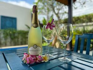 eine Flasche Champagner und zwei Gläser auf dem Tisch in der Unterkunft Villa Ginger with private pool Bang Tao in Phuket