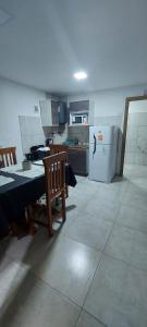 聖胡利安港的住宿－Cabañas Mailen'S，厨房配有桌椅和冰箱。
