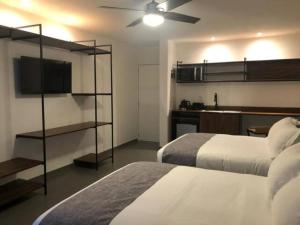 a hotel room with two beds and a ceiling fan at Urban Gran Plaza in Guadalajara