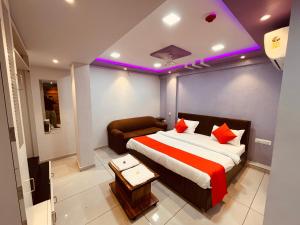 a hotel room with a bed and a couch at FabHotel Lake View I in Dabhoi