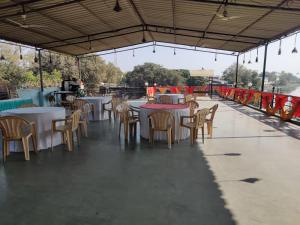a group of tables and chairs in a restaurant at FabHotel Lake View I in Dabhoi