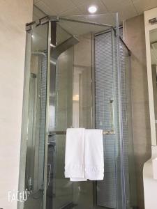 a glass shower stall with a towel hanging on it at Ocean Star Condominium in Seogwipo