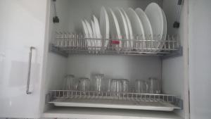 a refrigerator filled with lots of white plates and bowls at OSKO GRAND REVIERA, 10TH FLOOR, VENPALAVATTOM, NEAR KIMS HOSPITAL, TRIVANDRUM, KERALA in Trivandrum