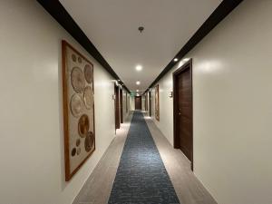 a hallway with a long corridor with paintings on the walls at Bluewater Maribago Beach Resort in Mactan